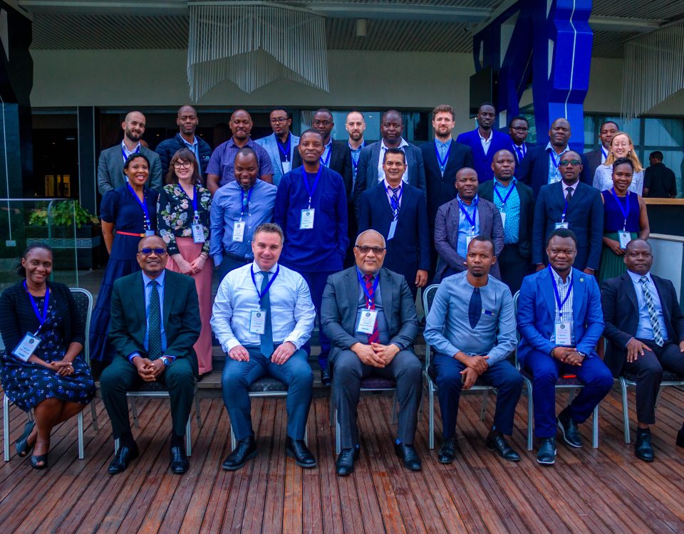 Group photo of attendees of the HE-COP meeting. Front attendees seated, with two rows of attendees stood behind.
