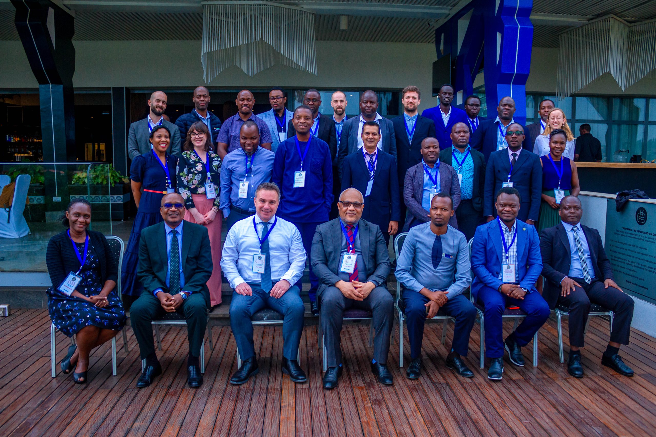 Group photo of attendees of the HE-COP meeting. Front attendees seated, with two rows of attendees stood behind. 